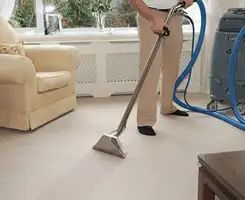 Carpet cleaning professional removing dirt and stains with a hot-water extraction tool in a home, Jackson, MS.