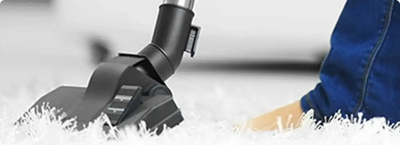 Close-up of a professional vacuuming a white carpet in Brandon.